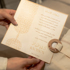 Hand holding a decorative envelope of the Bamboo and cotton nest with Arabic text and a wooden seal.