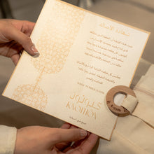 Hand holding a decorative envelope of the Bamboo and cotton nest with Arabic text and a wooden seal.